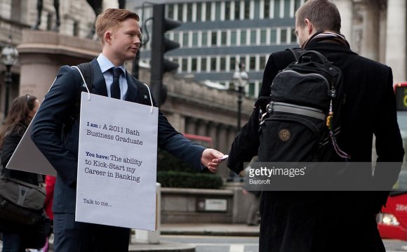 Hands a business card to a